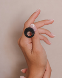 Black drop earrings with a round, dark stone.