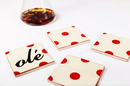 Set of 4 round coasters with a red polka dot pattern and the word "Ole" printed in black text. The coasters are made of a durable material and have a simple, modern design.