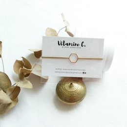 Gold-toned charm bracelet with hexagon-shaped charm featuring the brand name "Vitamine C."
