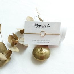 Gold-toned charm bracelet with hexagon-shaped charm featuring the brand name "Vitamine C."