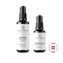 Two face oil products from the RESTORATIVE SET - a pristine essence and a midnight beauty serum. The pristine essence is a clear, lightweight facial oil, while the midnight beauty serum has a pink hue.
