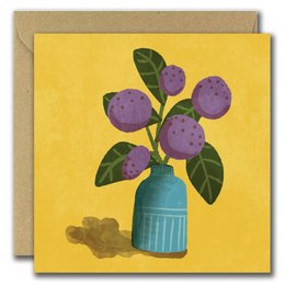 Purple pom pom flowers in a blue vase on a yellow background.