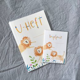  Vaccination certificate cover with a lion design, suitable as a gift for pregnancy or birth. The cover features a cute lion illustration and the text "U-heft" which likely refers to a vaccination or medical record book.