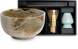 Large matcha bowl with whisk and accessories in gift box. Ceramic bowl with natural speckled glaze finish. Includes matcha whisk, scoop, and tea caddy.