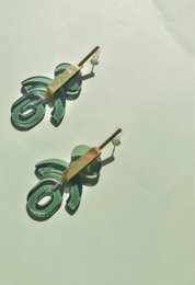 Geometric drop earrings in milky seafoam green, glass ruby, tortoise, and glass green colors. Featuring abstract, asymmetric shapes with a modern, statement style.