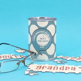 "Puzzle with the message 'You're a great Grandpa' on a blue background with glasses and a tin can."
