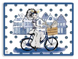 Delftsblauw Zeeland placemat with a woman riding a bicycle in front of traditional Dutch houses, featuring a blue and white color scheme with polka dot patterns.