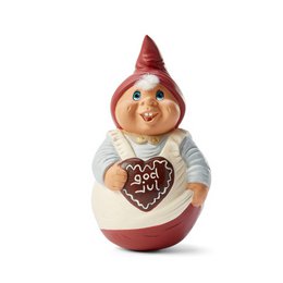 A round, red and white ceramic figurine of a smiling gnome or elf-like character holding a heart-shaped gingerbread cookie.