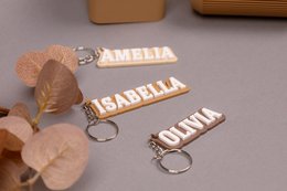 Personalized keychain in beige, light brown, and dark brown colors. Made of sustainable materials, suitable as a gift for her, him, or kids, and for school or graduation.