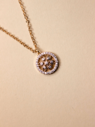 Elegant gold-tone necklace with a circular pendant featuring a floral design and sparkling crystals.