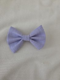 Lavender-colored hair clip with a bow design, suitable for children.