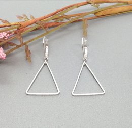 Silver triangle earrings with a simple, minimalist design.