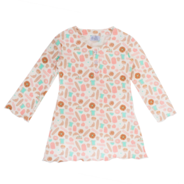 A colorful, patterned dress for kids featuring a variety of shapes and dots in pastel shades.