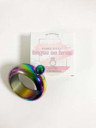 Colorful, iridescent metal bracelet with a flask-shaped charm for bachelorette parties.