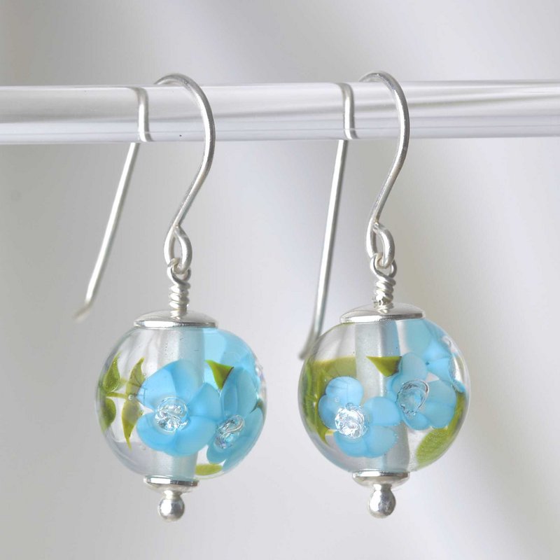 Essenziali orecchini con fiori in vetro celeste scuro