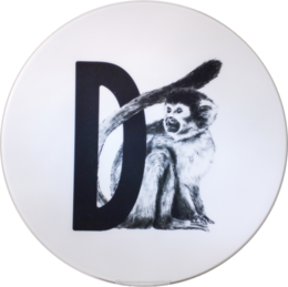 A round white plate with a black and white image of a monkey on the letter 'D'.