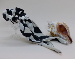 Black and white patterned headband with a bow detail.