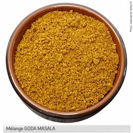 Mixture of aromatic spices in a rustic earthenware bowl. Vibrant yellow-orange color, granular texture. Ideal for seasoning and flavoring a variety of dishes.
