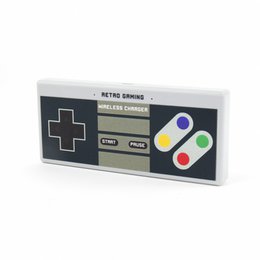 Retro-style wireless charger with classic gaming controller design, available in black and white colors.