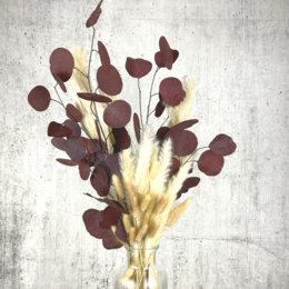 A bouquet of dried flowers in shades of red, with a rustic, vintage-inspired aesthetic.