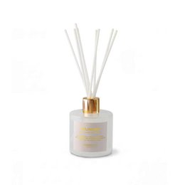 White cylindrical scented candle with gold lid, blue label, luxury home fragrance, aromatic decor.