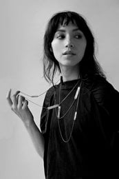Long round necklace made of metal chains in a silver color.