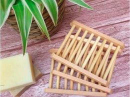 Rectangular bamboo soap dish with slatted design for drainage.