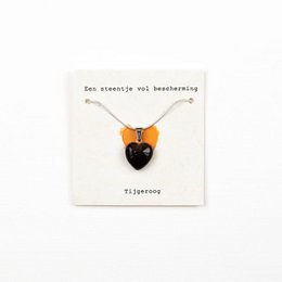 A necklace featuring a pendant made of tigereye stone, a natural gemstone known for its protective properties. The pendant has a heart-shaped design in a warm, earthy orange color.