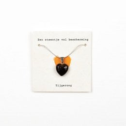 A necklace featuring a pendant made of tigereye stone, a natural gemstone known for its protective properties. The pendant has a heart-shaped design in a warm, earthy orange color.