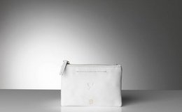 Small white leather clutch with zipper closure.