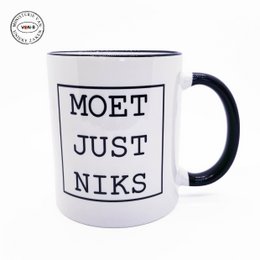  A simple black and white mug with the text "MOET JUST NIKS" printed on it. The mug is packaged in a brown cardboard box.
