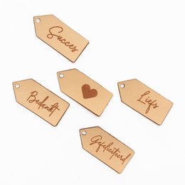 Leather gift tags in various designs and messages, including hearts, "Liefs", "Succes", "Gefeliciteerd", and "Bedankt".
The product images show a set of leather gift tags in various shapes and designs. The tags feature text messages such as "Liefs", "Succes", "Gefeliciteerd", and "Bedankt", as well as a heart symbol. The tags appear to be made of a light-colored leather material and have a rustic, handcrafted aesthetic.