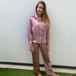 Soft pink silk pajama set with long sleeves and button-down closure. Relaxed, comfortable fit perfect for lounging at home.