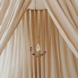 Amethyst pendant with dreamcatcher design, featuring a teardrop-shaped amethyst stone suspended from a gold-toned metal hoop surrounded by delicate pink flowers.