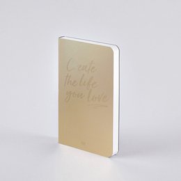 A golden-colored book with the text "Create the life you love" embossed on the cover.