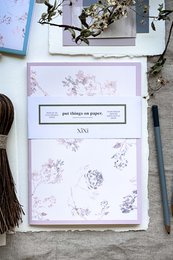 Soft pink notebook with puff blue framing, featuring a delicate floral pattern design.