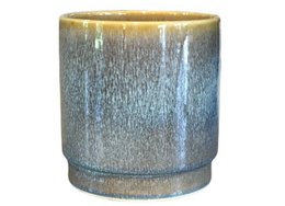 A round, tall ceramic plant pot with a reactive jade blue glaze.