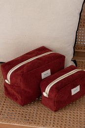  Burgundy corduroy toiletry bags with white trim, available in two sizes.