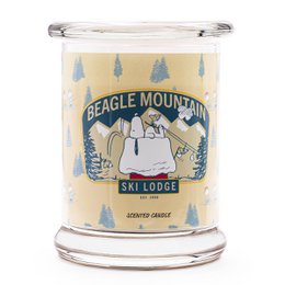 Scented candle with a round, tall shape. The candle has a label featuring the "Beagle Mountain Ski Lodge" design, which includes pine trees and a winter landscape. The candle is made of a light-colored wax.