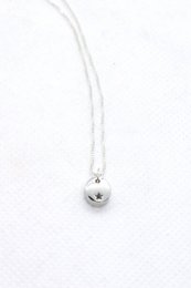 A high-quality silver necklace with a copper star charm pendant. The necklace features a simple, elegant design with a shiny silver chain and a copper star-shaped charm.