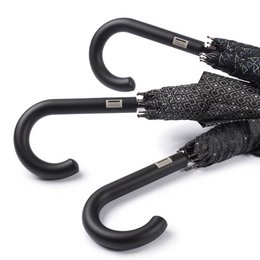 Long, black and white patterned umbrella with curved handle.