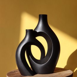 Tall, black ceramic vases with an intertwined, spiral design.