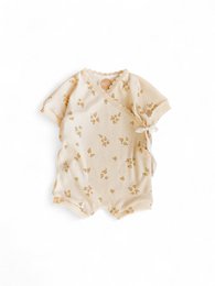 Soft, natural-colored baby romper with tiny floral print. Available in sizes 1-3, 3-6, 6-9, and 9-12 months.