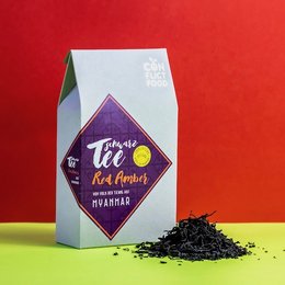 Organic black tea "Red Amber" in a peace package. The tea leaves are dark in color and appear to be of high quality. The package design features a diamond-shaped label with the text "Tit" and "Organic black tea" printed on it.