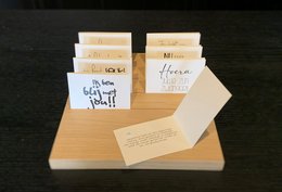 A collection of greeting cards with handwritten text on a wooden surface.