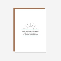 A greeting card with a simple illustration of a sun and the text "Enjoy life" printed on it. The card has a minimalist, modern design.