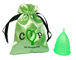A green menstrual cup in a satin drawstring bag with the text "De Groene Cup" printed on it. The cup is made of flexible, medical-grade silicone and comes in 5 different models.