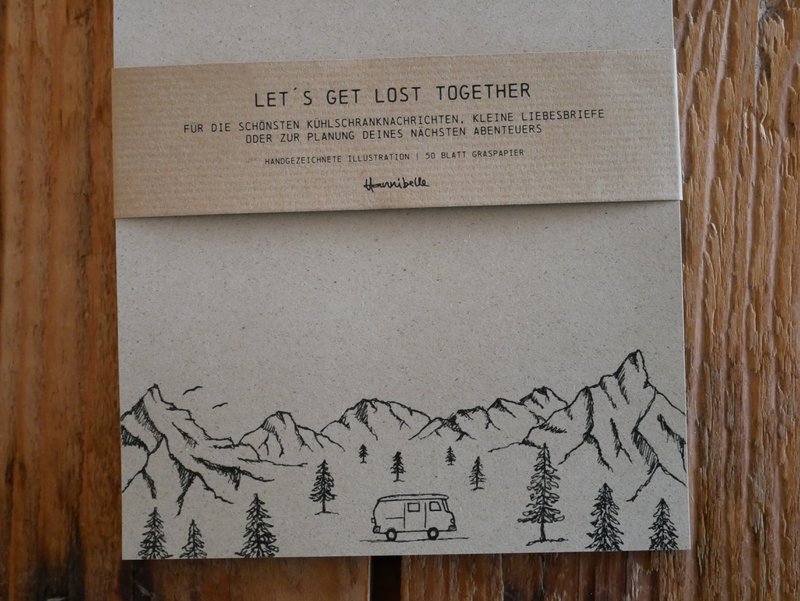 Camper con blocco note in carta erba in montagna