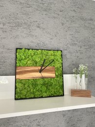Olive wood and moss wall clock with horizontal and vertical orientation options. Features a natural, earthy design with a wooden frame and a moss-covered face, creating a unique and rustic aesthetic.