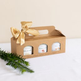  "Gift box containing 3 Christmas-themed candles in a transparent jar. Candle scents include barley sugar, Christmas tree, gingerbread, Christmas cookie, and apple cinnamon. Packaged in a wooden gift box with a ribbon."
